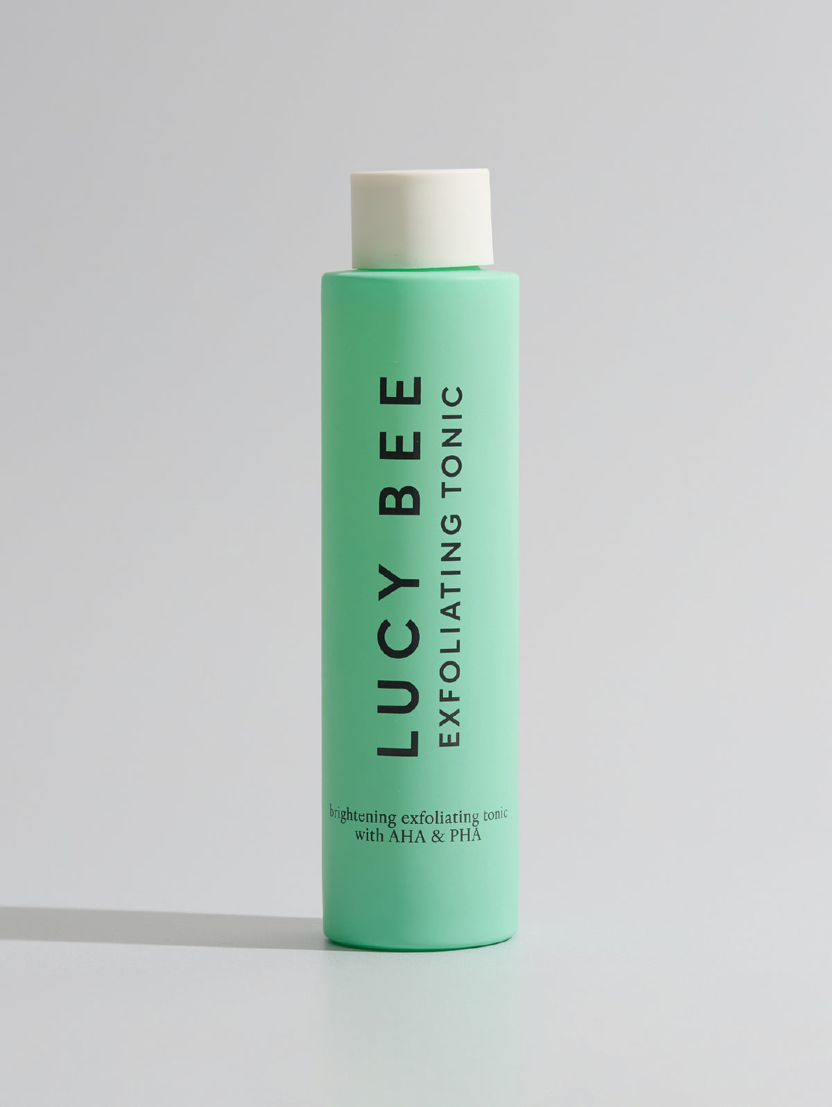Green bottle of Lucy Bee Exfoliating Tonic on a white background