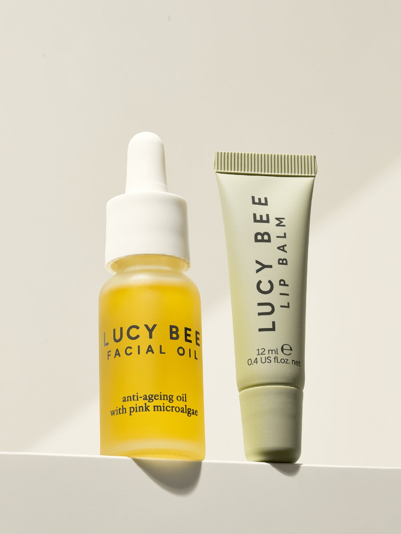 Lucy Bee facial oil and lip balm on a light background