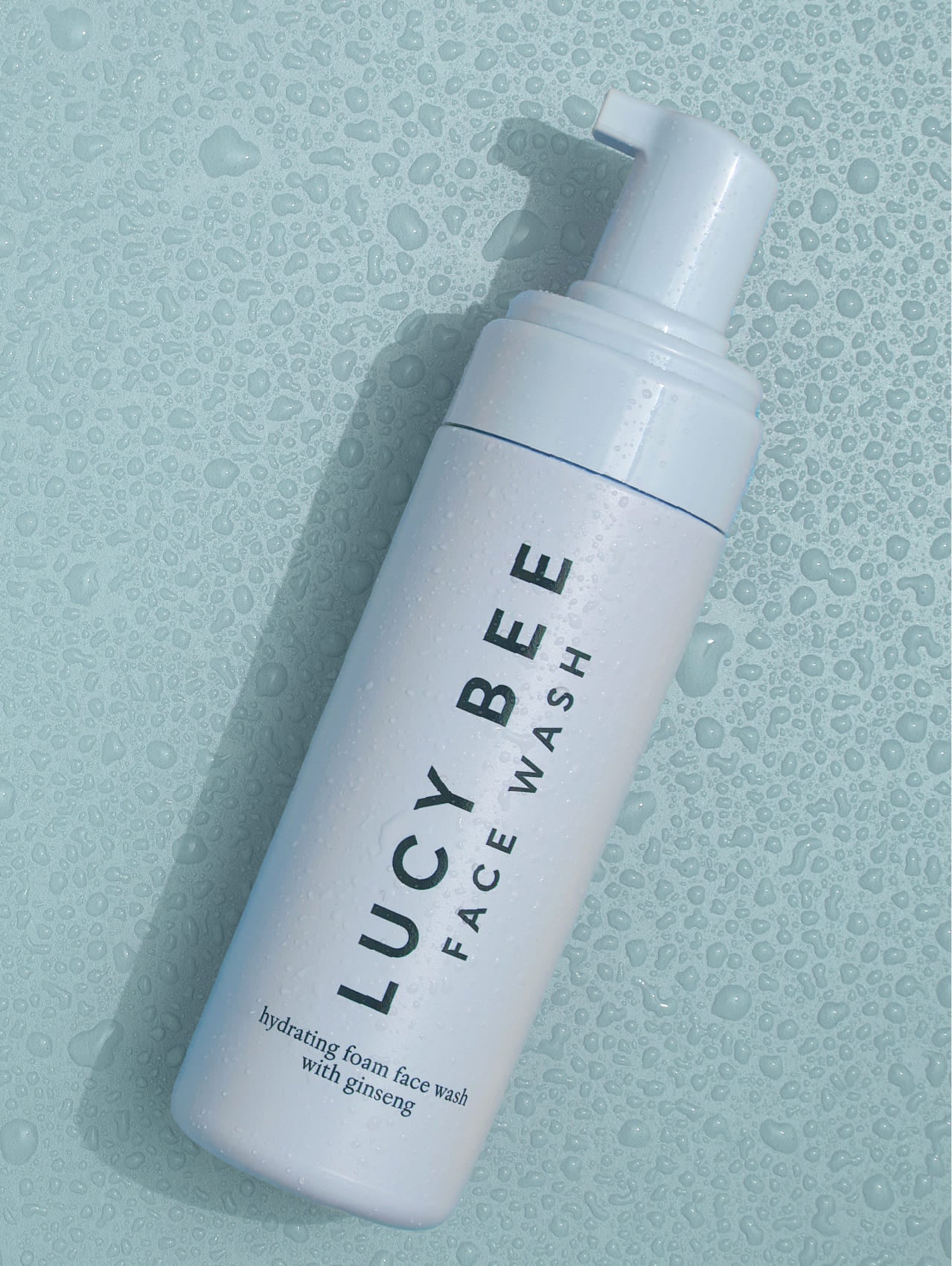 Lucy Bee face wash bottle on a textured light blue background