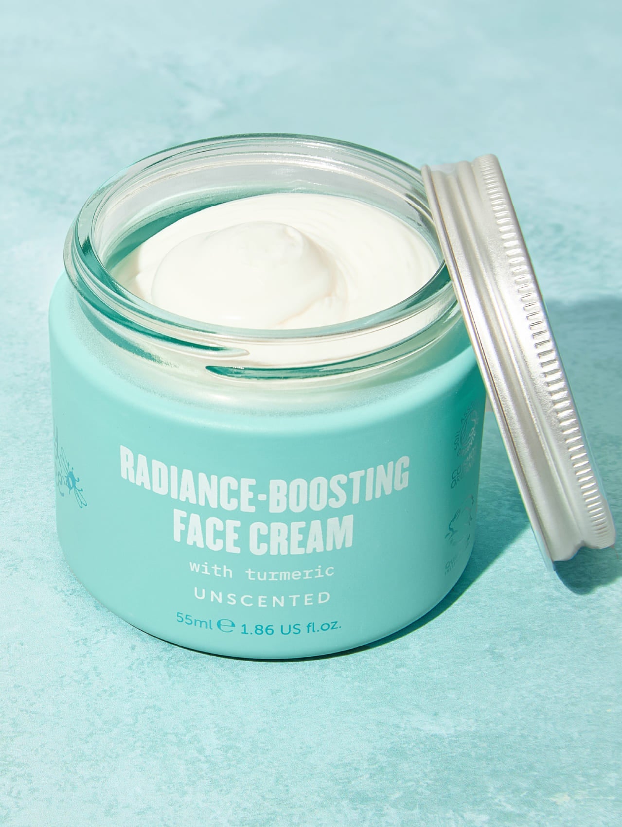Jar of Lucy Bee radiance-boosting face cream on a light blue background