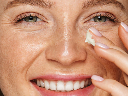 Woman applying Lucy Bee Organic Anti-Ageing Eye Cream near her eye
