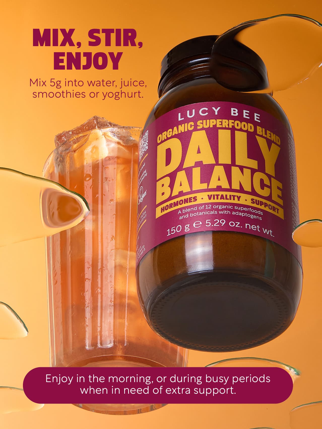 Lucy Bee Daily Balance superfood blend bottle with a drink in the background on an orange background. Lucy Bee organic daily balance to support stress and times when you may feel out of balance