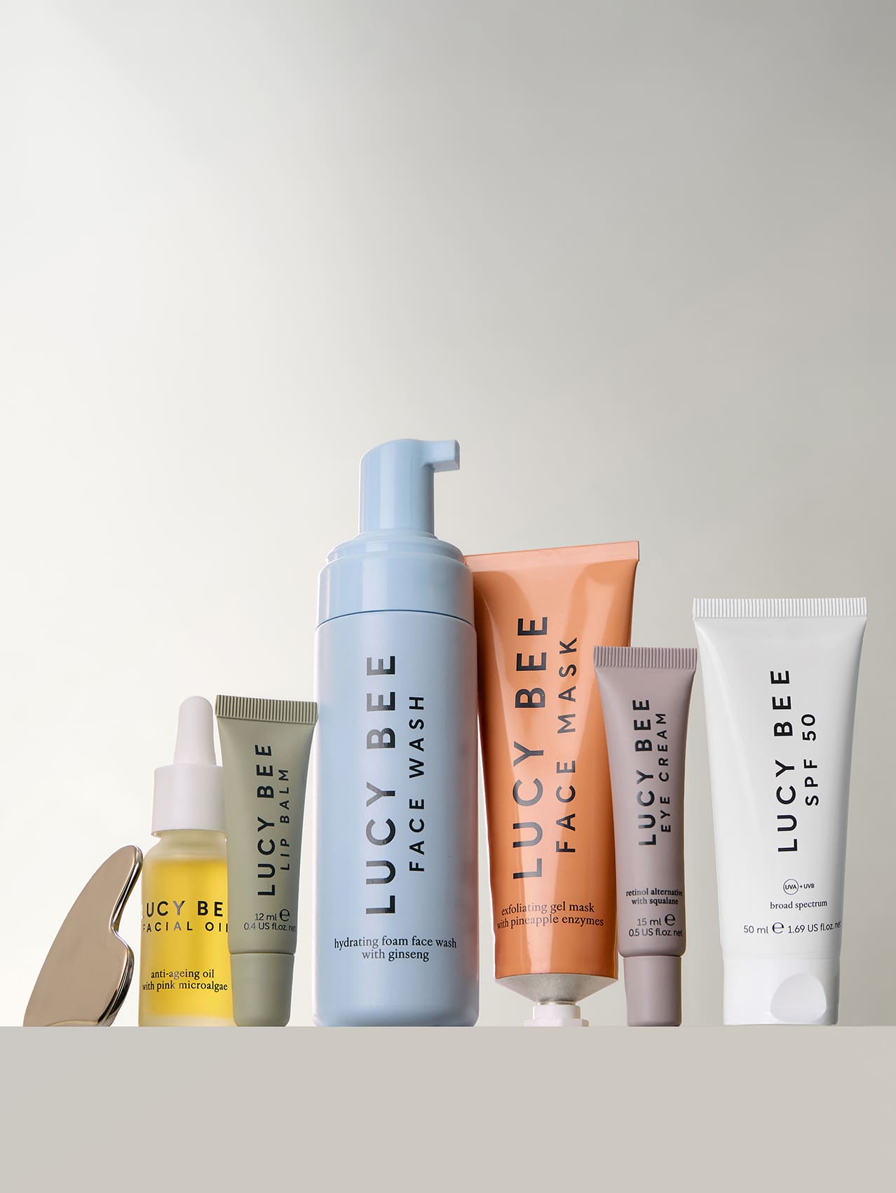 Collection of Lucy Bee skincare products on a light gray background