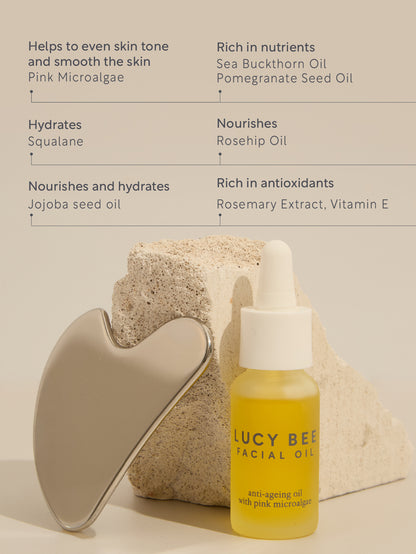 Lucy Bee facial oil bottle with skincare tools on a neutral background