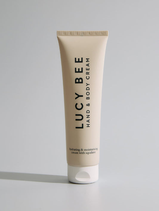 Tube of Lucy Bee hand and body cream on a gray background