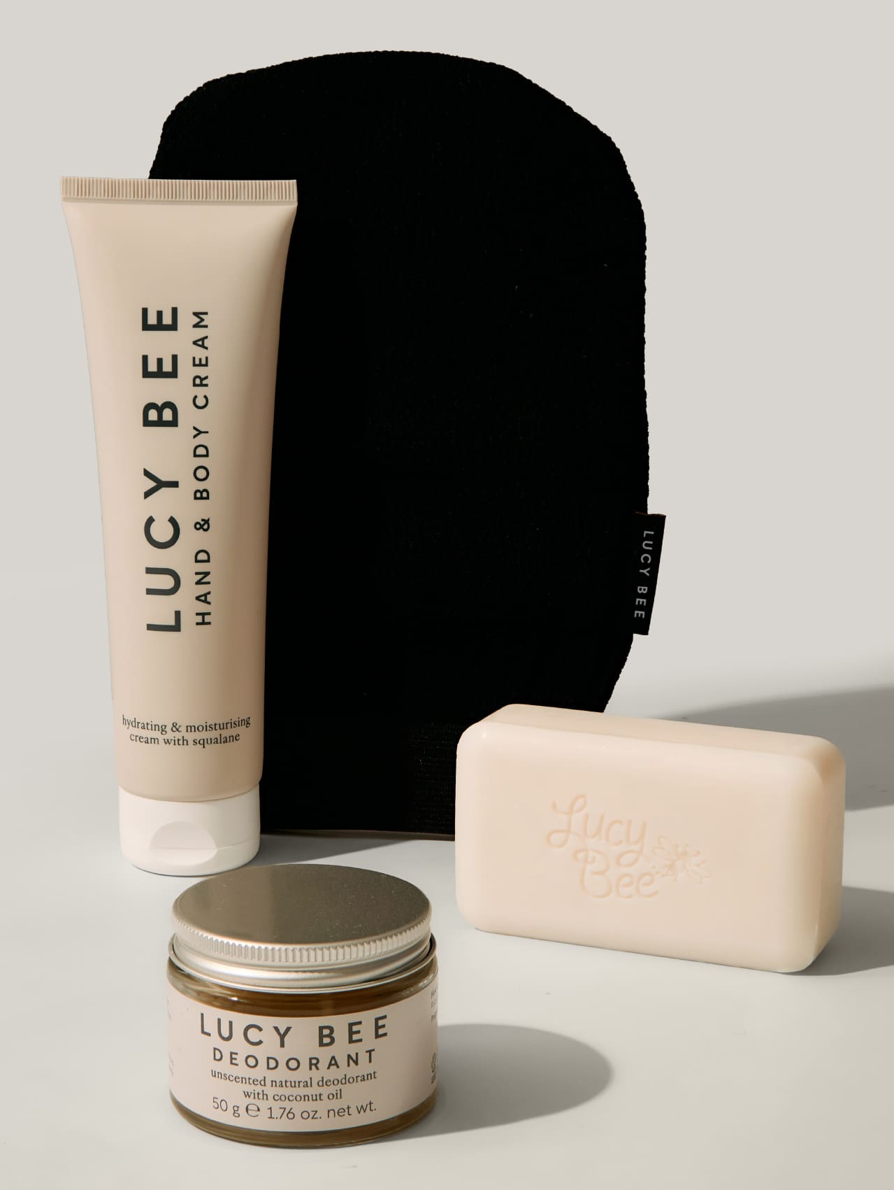 Lucy Bee skincare products including cream, deodorant, and soap on a neutral background