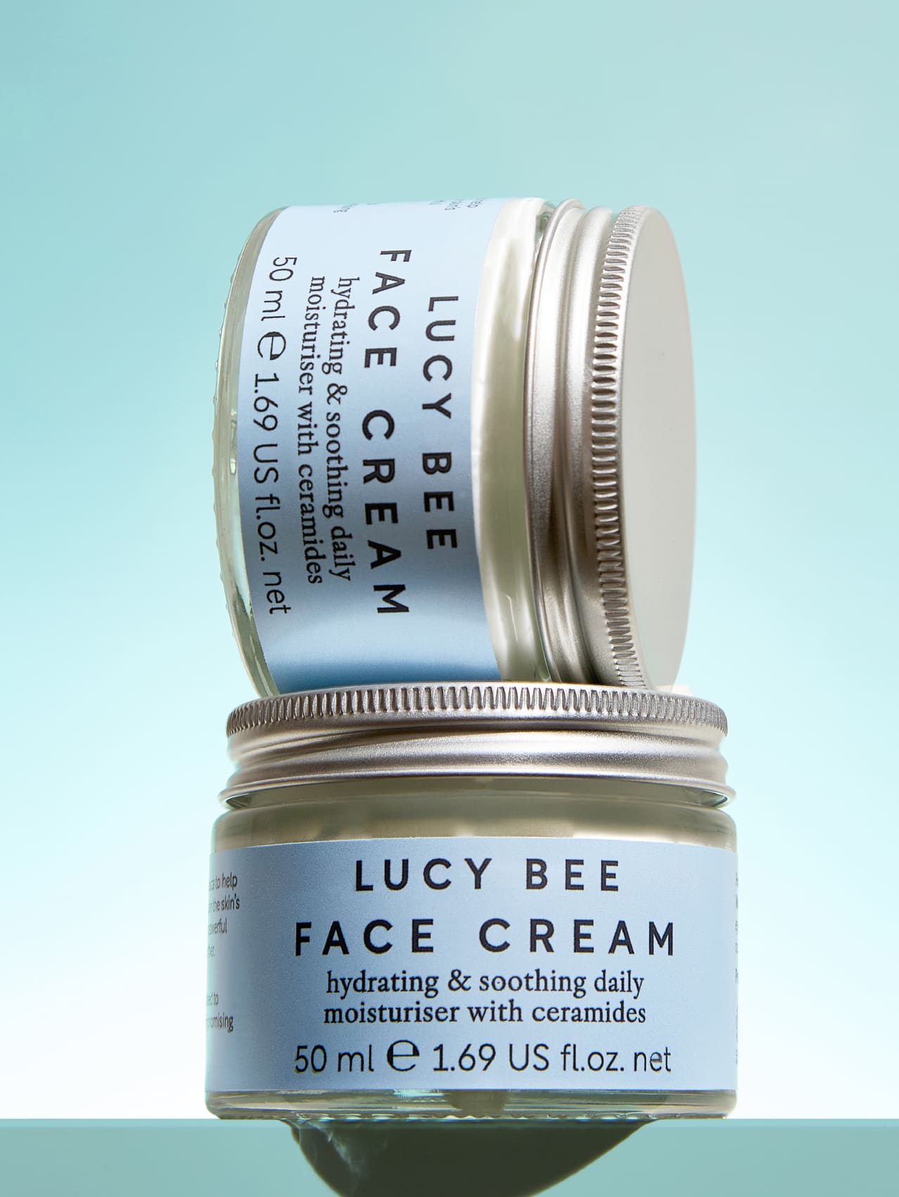 Two jars of Lucy Bee Face Cream on a light blue background