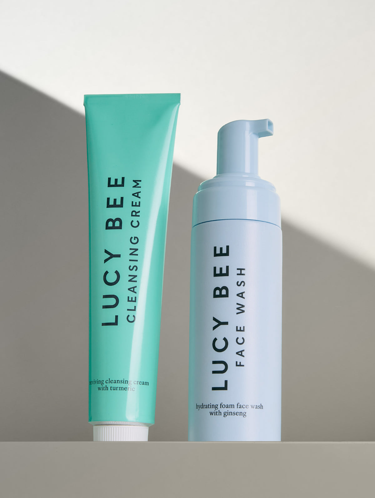 Two skincare products from Lucy Bee on a gradient background