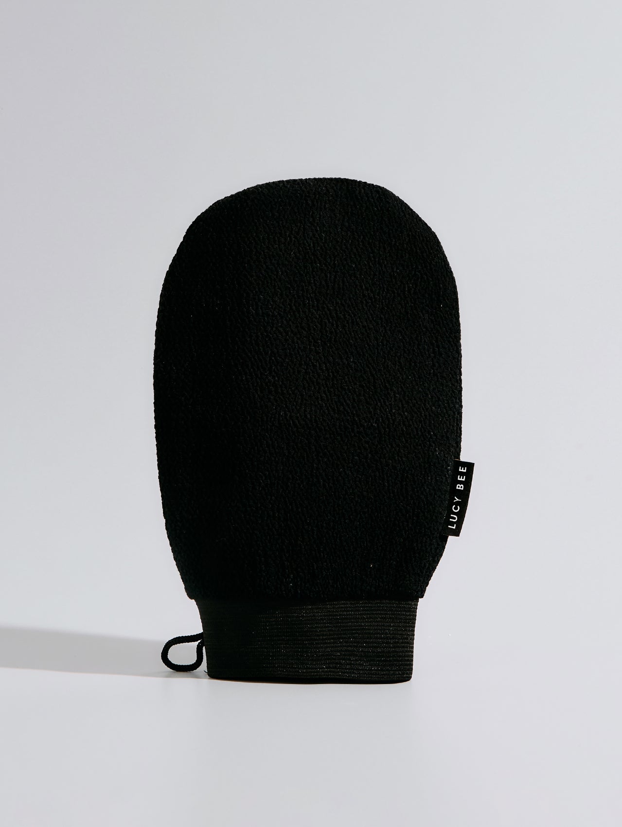 Black exfoliating mitt on a light gray background