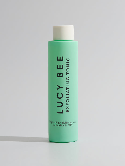 Green bottle of Lucy Bee Exfoliating Tonic on a white background