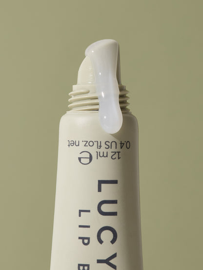 Lucy Bee lip balm bottle on a beige background
