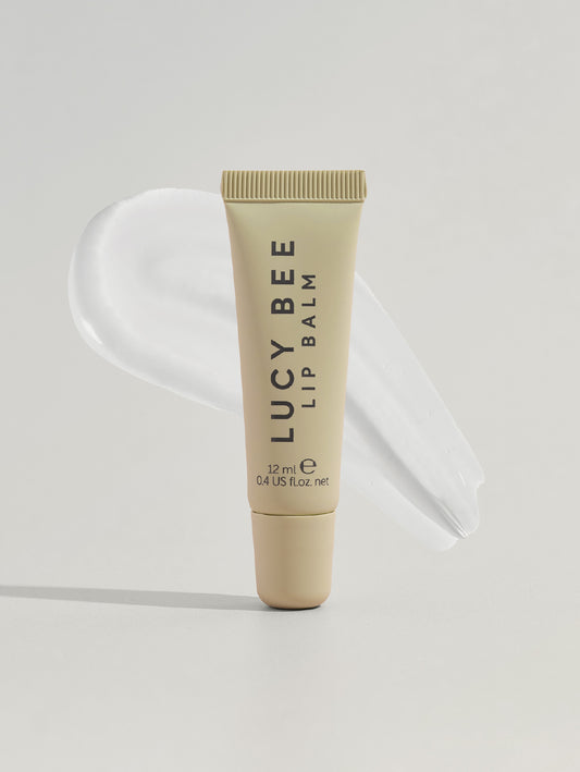 Lucy Bee lip balm tube on a light gray background