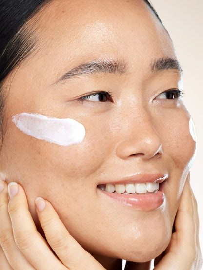 Close-up of a person applying Lucy Bee Night cream to their face