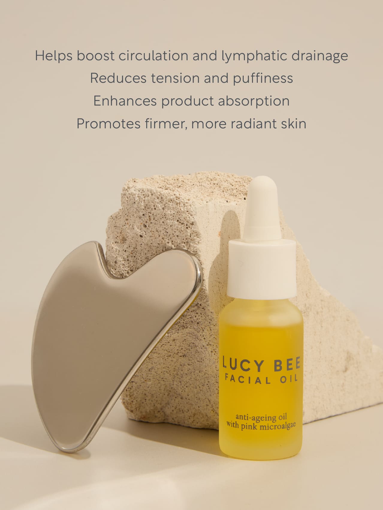 Bottle of Lucy Bee facial oil with a Gua Sha on a neutral background