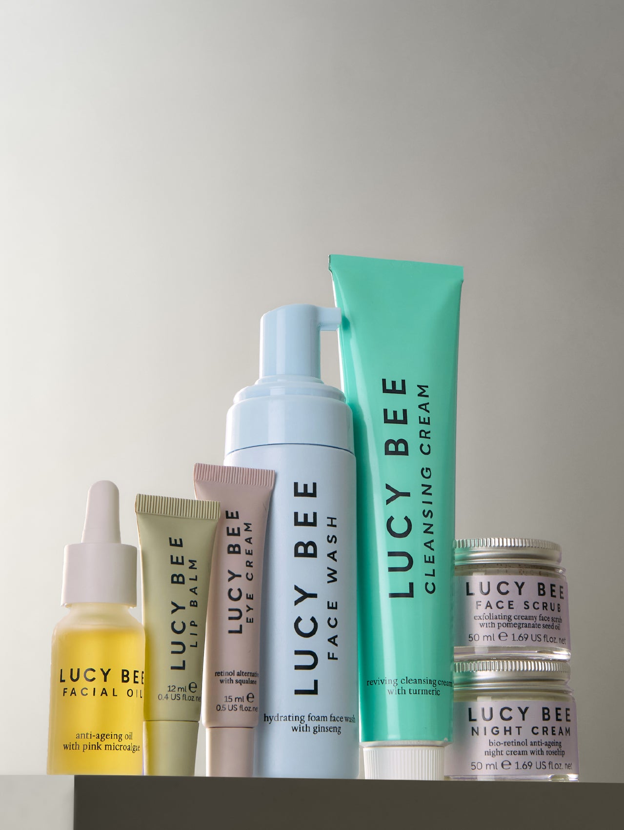 Collection of Lucy Bee Natural skincare products on a gray background
