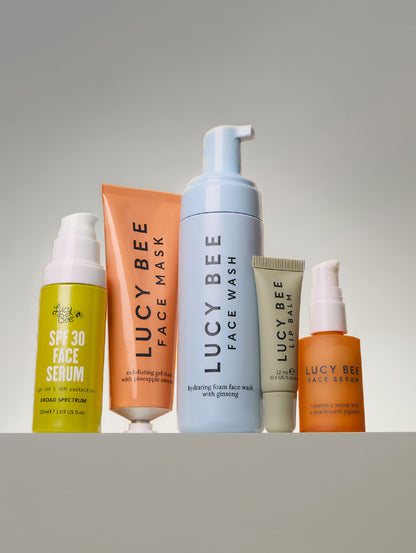 Set of Lucy Bee natural skincare products on a gray background