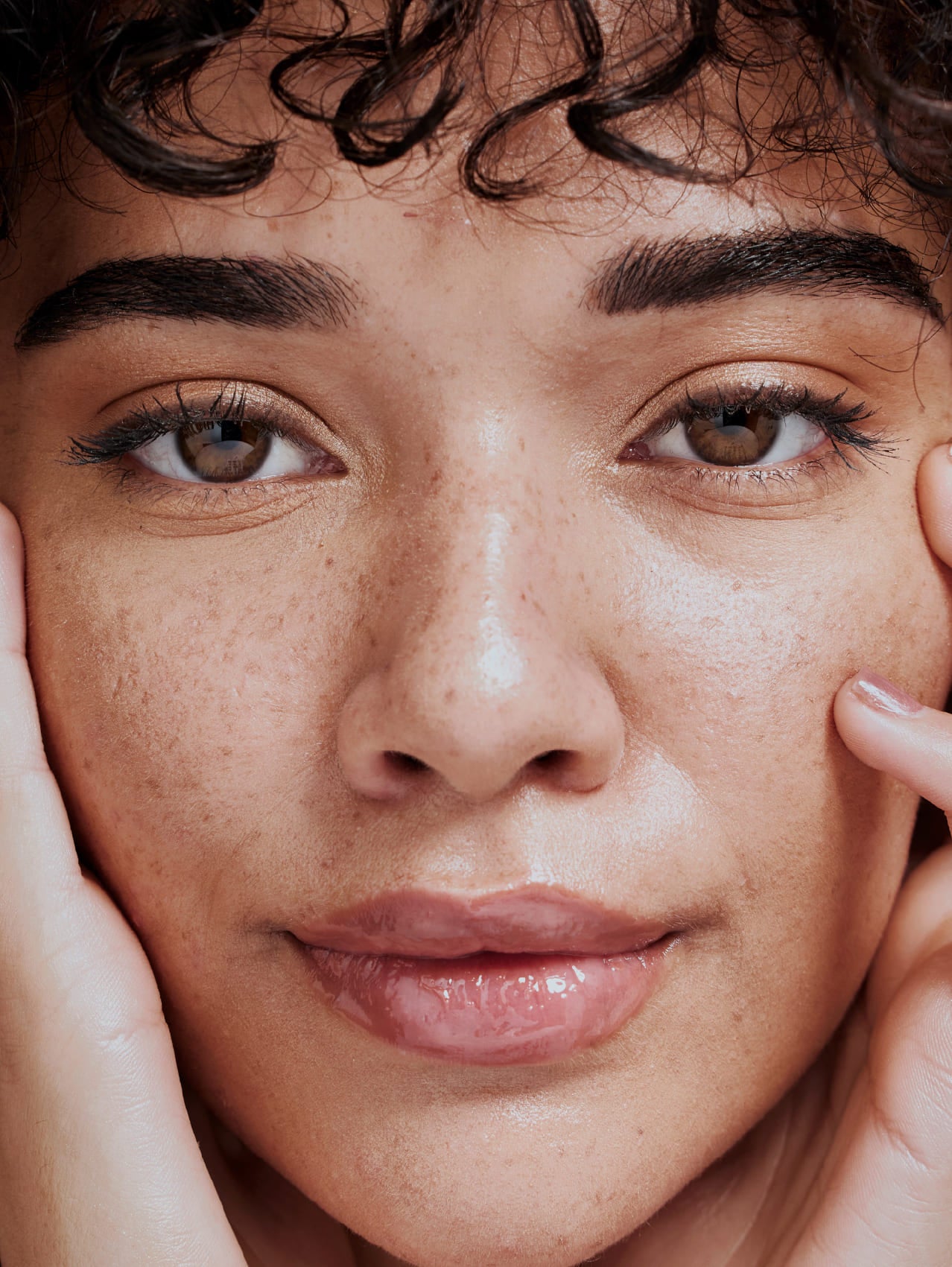 Close-up of a person with natural makeup and soft smile having used SPF