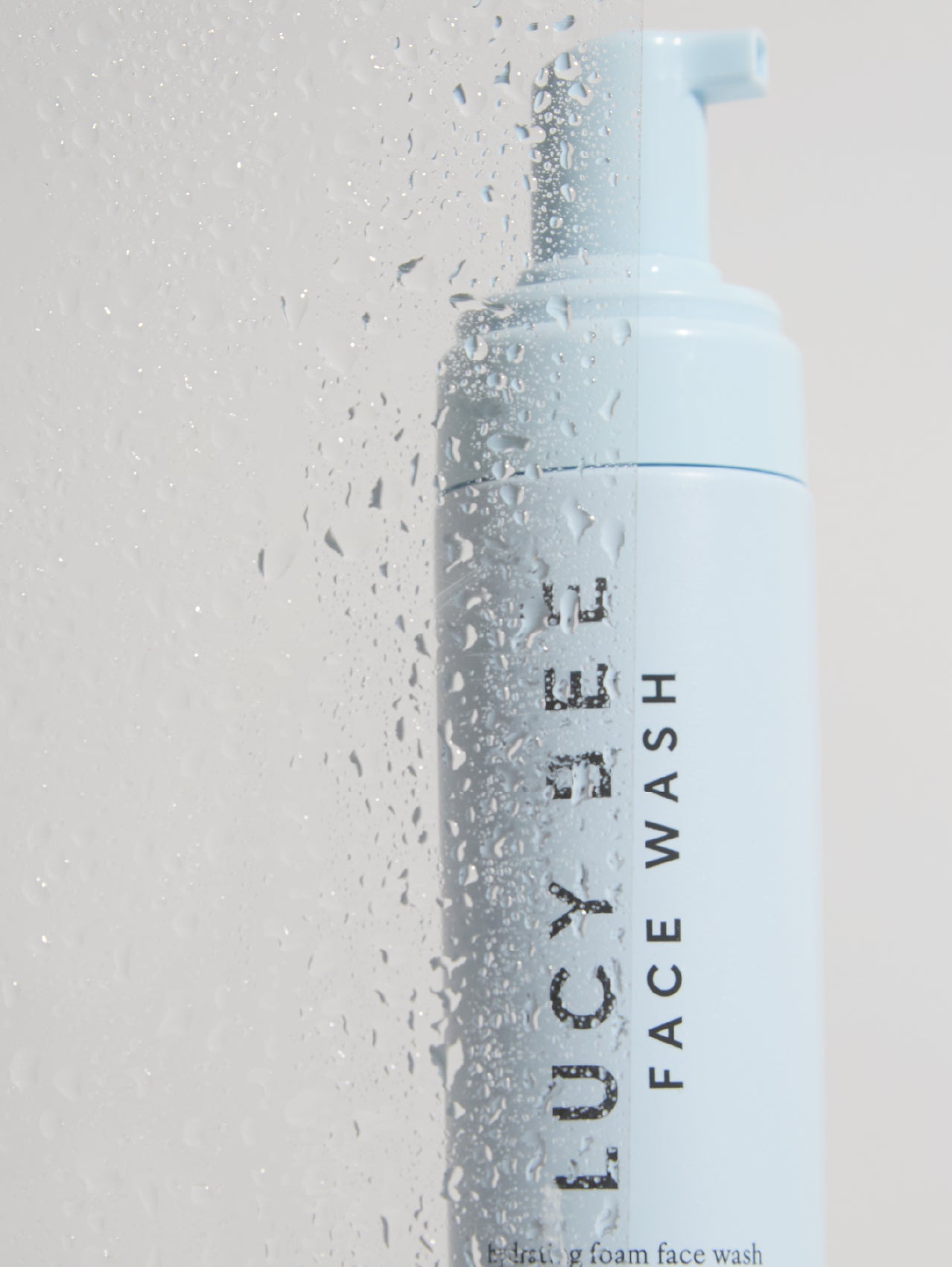 Lucy Bee face wash bottle with pump on a light gray background