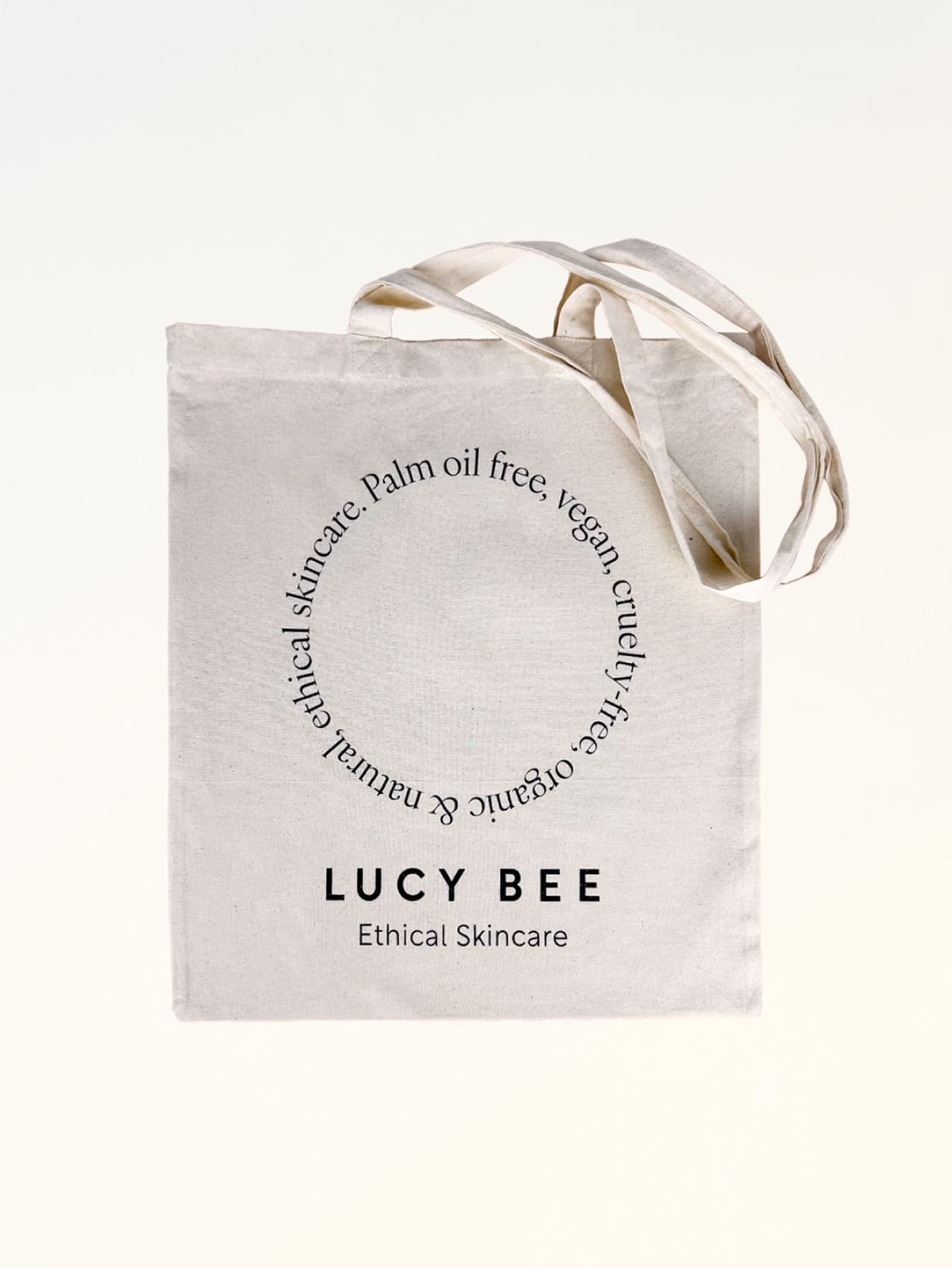 Lucy Bee tote bag with a ribbon on a white background