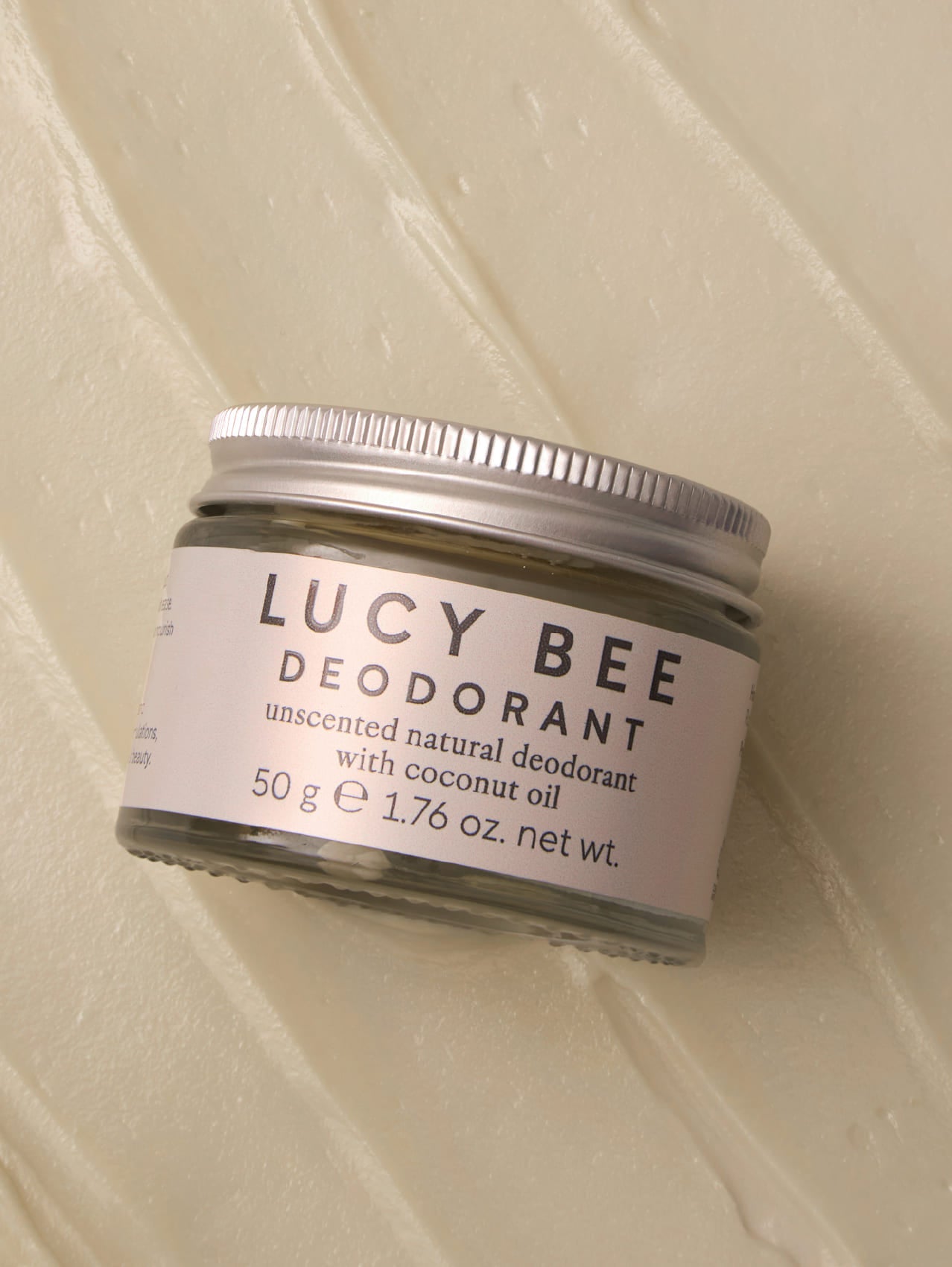 Lucy Bee deodorant jar on a textured beige background