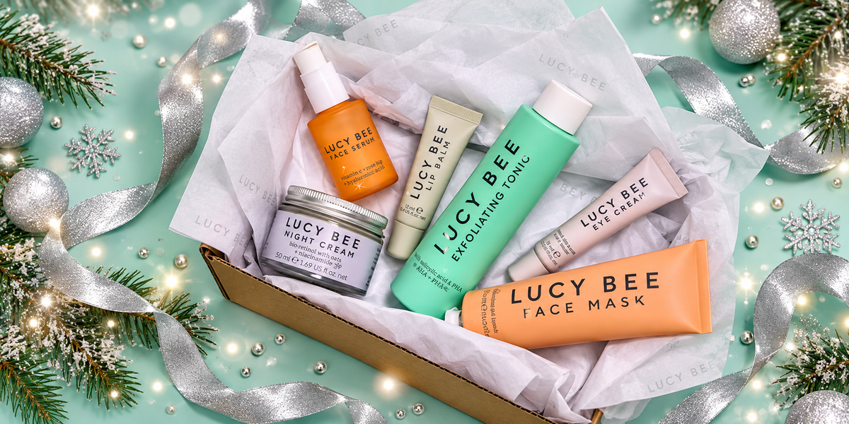 Lucy Bee skincare in a festive gift box with silver ribbon and Christmas foliage